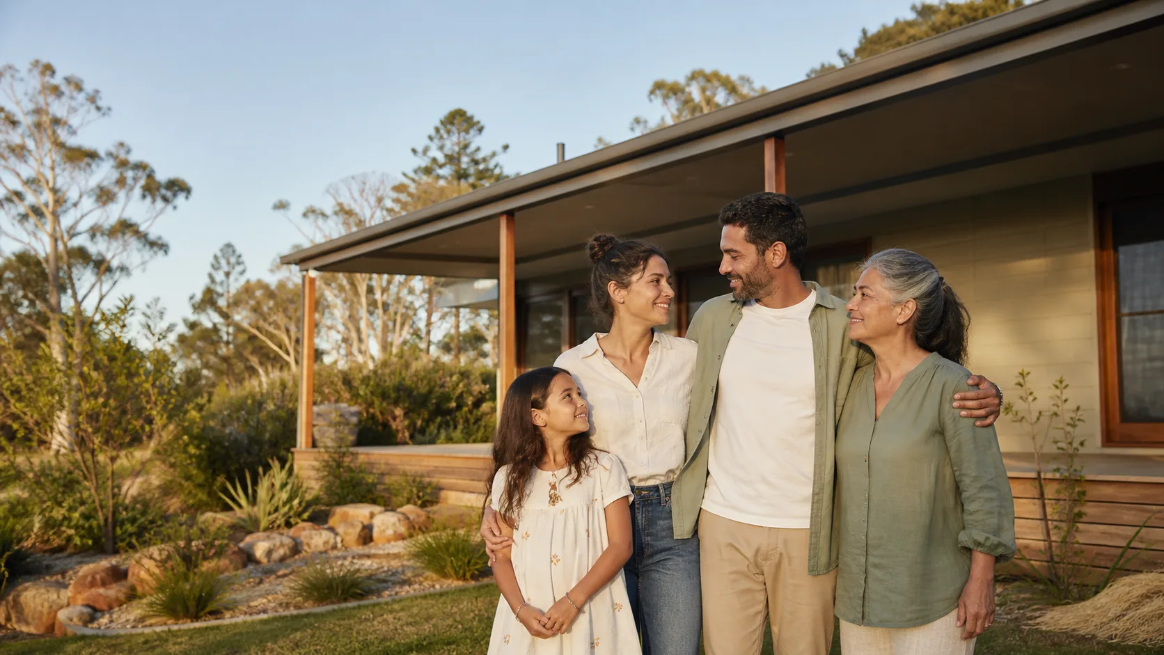 A multigenerational Australian family outside their new home